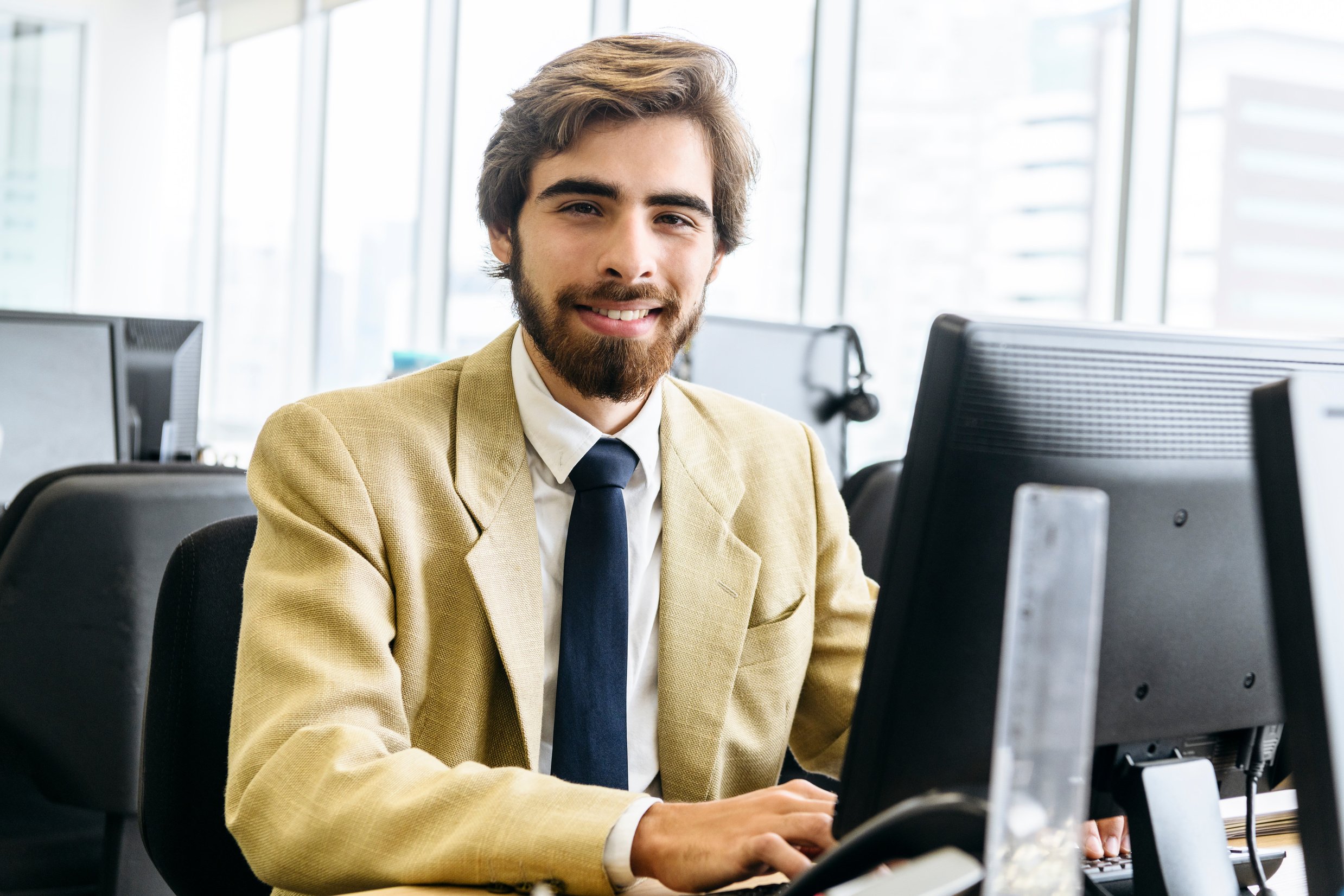 Cheerful businessman using desktop pc